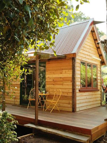a log cabin with a table and chairs on a deck at RR Tiny House - in town sanctuary, pet friendly in Margaret River Town