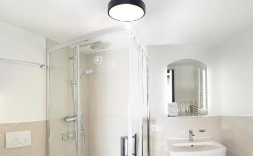 a bathroom with a shower and a toilet and a sink at Hotel Kniebis-Stuben in Kniebis