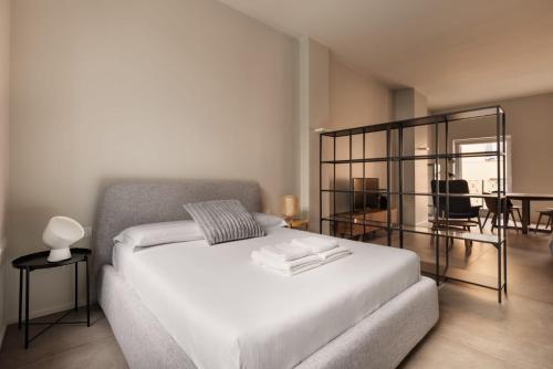 a bedroom with a white bed and a dining room at Donizetti Studios in Bergamo