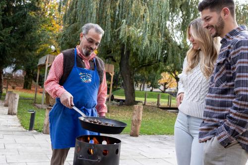 a man and a woman cooking food in a pan at Das Parkhotel in Bad Wörishofen