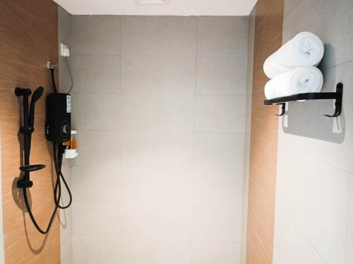 a bathroom with a shower with towels on the wall at Keteri Boutique Hotel in Kangar