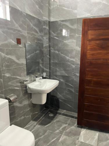 a bathroom with a white sink and a toilet at SV Guest House in Kokkuvil East