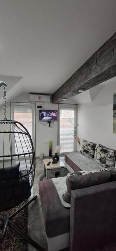 a living room with a bed and a couch at APARTMENTS IVANOViC CENTER CITY in Bajina Bašta