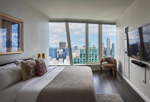 a bedroom with a large bed and a large window at Lux Apts with Lake Views and Top Amenities in Chicago