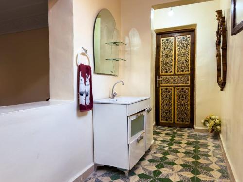 a bathroom with a sink and a mirror and a door at vintage in Fez