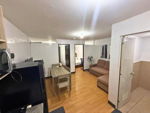 a living room with a couch and a table at 2-Bedroom Condo in Imus Cavite with UNLI WIFI, 50" TV, Netflix, Family Computer, Pool in Imus