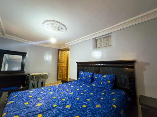 a bedroom with a blue bed with yellow flowers on it at vintage in Fez