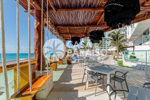 a restaurant on the beach with tables and chairs at *TURQUOISE ESCAPE- Beachfront Studio by Casa Paraiso* in Cancún
