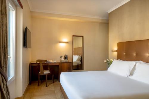 a hotel room with a bed and a desk at UNA Hotels Galles Milano in Milan