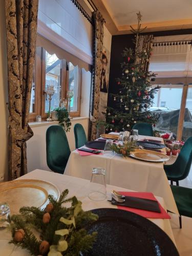 a dining room with a christmas tree in the background at Gordonówka Grand- blisko basenów termalnych Rezerwuj już dziś- nie przegap okazji! in Szaflary