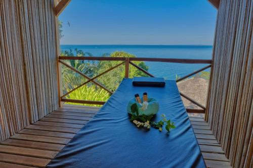 a table on a balcony with a view of the ocean at Manja Kely Lodge in Nosy Be