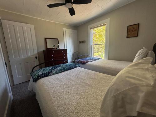 a bedroom with two beds and a window at Farmhouse by Ricketts Glen in Benton