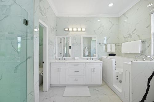 a white bathroom with a sink and a shower at Plunge into Joy & Bayfront Magic at Seaside Escape - Villa Seabird in Apollo Beach