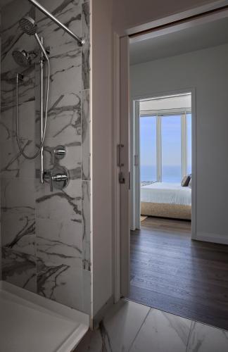 a bathroom with a shower and a bedroom at Lux Apts with Lake Views and Top Amenities in Chicago