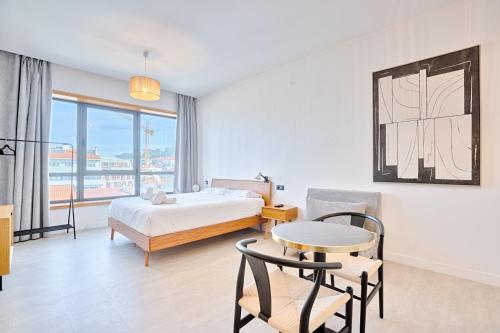 a bedroom with a bed and a table and chairs at Lindo apartamento Porto - Gaia in Vila Nova de Gaia