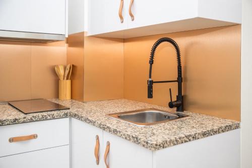 a kitchen counter with a sink and a faucet at Lindo apartamento Porto - Gaia in Vila Nova de Gaia