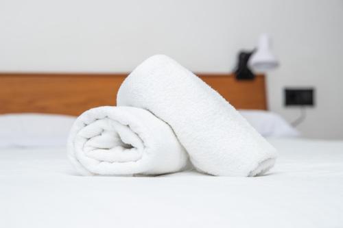 a roll of white toilet paper sitting on a bed at Lindo apartamento Porto - Gaia in Vila Nova de Gaia