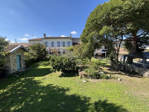 a yard with an old car in front of a house at Maison JEROBOAM in Saint-Estèphe