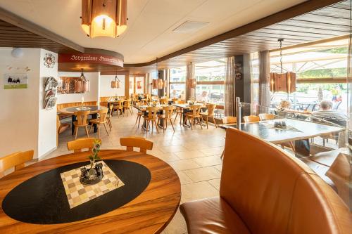 a restaurant with tables and chairs in a room at Hotel Seehof Superior in Walenstadt