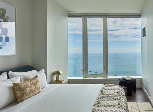 a bedroom with a large bed with a large window at Lux Apts with Lake Views and Top Amenities in Chicago
