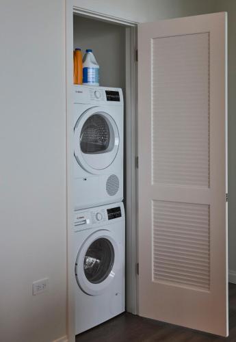 a laundry room with a washer and dryer next to a door at Lux Apts with Lake Views and Top Amenities in Chicago