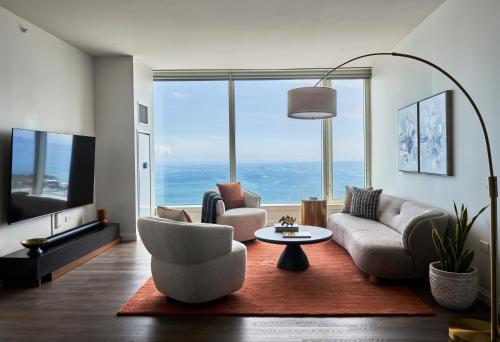 a living room with couches and a large window at Lux Apts with Lake Views and Top Amenities in Chicago