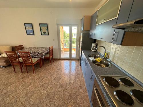 a kitchen with a table and a dining room at Apartment Visum in Primošten