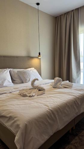 a white bed with two towels on top of it at Moment in Strzelce Opolskie