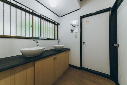 a bathroom with two sinks and a large window at ItsumoYuki in Atami