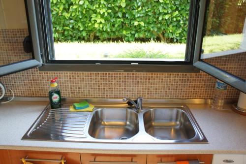 a sink in a kitchen with a window above it at Ixia Beach in Ialyssos