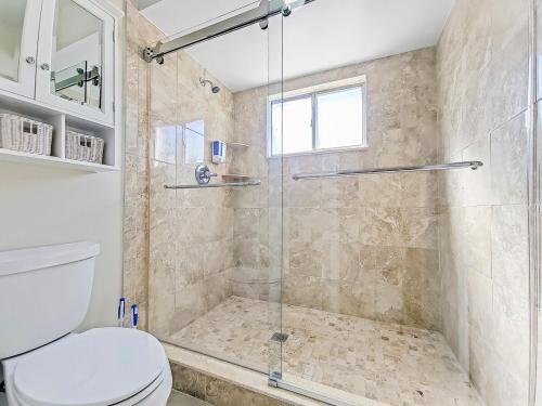 ザファーヒルズにあるDelightful Family Home in New Tampaのトイレとガラスのシャワー付きのバスルーム