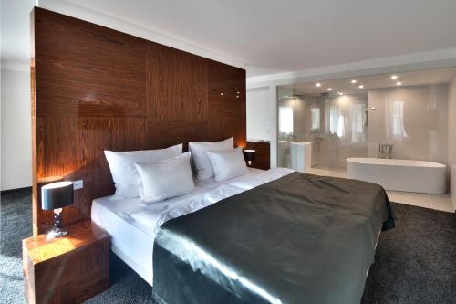 a bedroom with a large bed and a bath tub at Prezident Luxury Spa & Wellness Hotel in Karlovy Vary