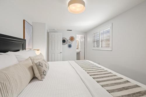 a white bedroom with a white bed with a black headboard at Summer Nights in Bailey Hall