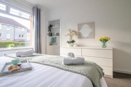 a white bedroom with two beds and a window at Ashgrove House - 3 bedroom in Coatbridge