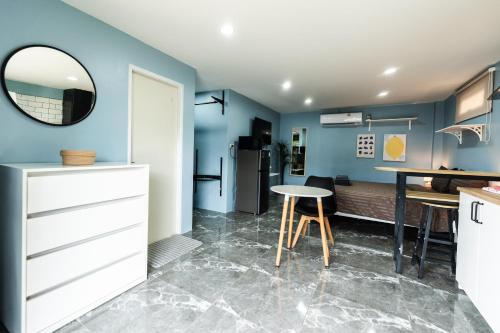 a kitchen with blue walls and a table and a mirror at Apollo Hotel Chalong in Ban Suan