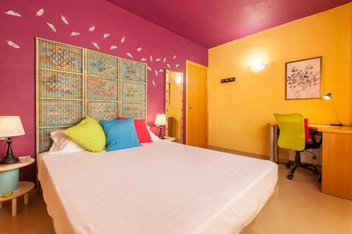a bedroom with a white bed and colorful walls at La Cantonada in Sant Pere de Ribes