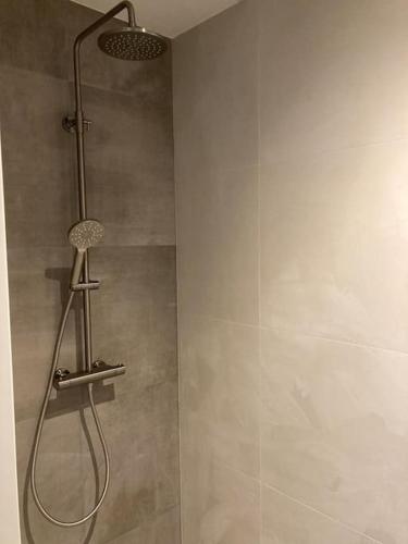 a shower with a shower head in a bathroom at Weidezicht Soest, beauty & wellness en rust & natuur in Soest