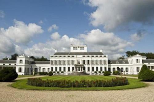 a large white building with a garden in front at Weidezicht Soest rust en natuur in Soest
