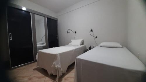 two beds in a room with a window at Cozy Family Home - COP 30 in Belém
