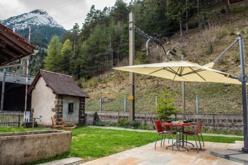 a table and chairs with a yellow umbrella in a yard at Eggwald in Wassen
