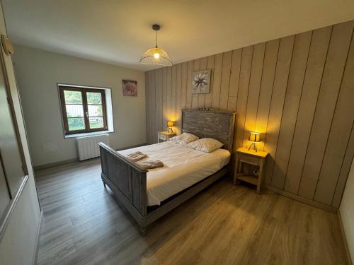 a bedroom with a bed and two tables with lamps at La maison Cécile 15/17 pers in Étais-la-Sauvin