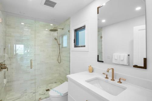 a white bathroom with a sink and a shower at Siesta Beachfront Paradise in Siesta Key