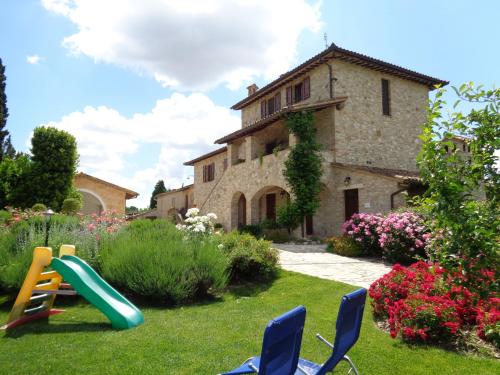 托迪Agriturismo La Torraccia的房屋前带椅子和滑梯的院子