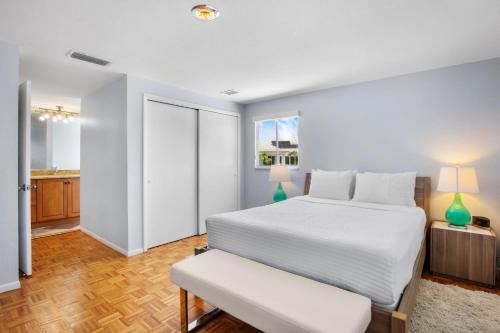 a bedroom with a large white bed and a table at Leona Breeze in Bailey Hall