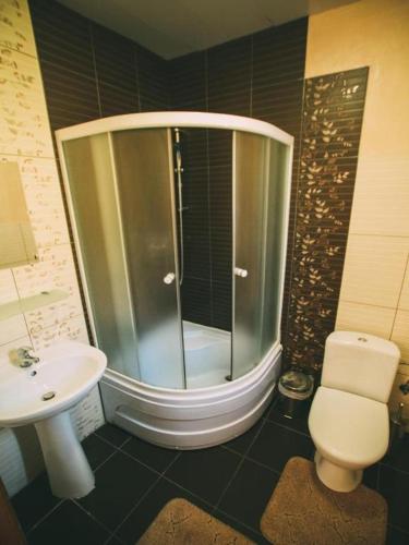 a bathroom with a shower and a toilet and a sink at Dobriy Hotel in Vorokhta