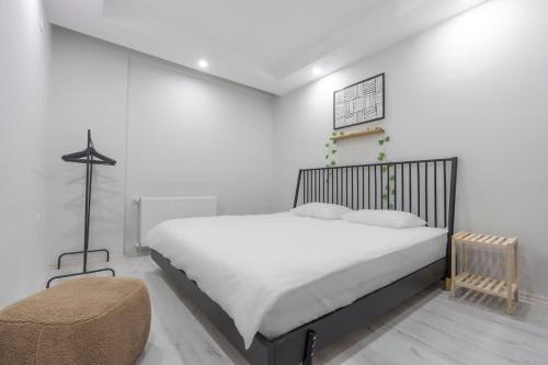 a white bedroom with a large bed and a chair at Boho Style Flat with Free WiFi Near Kaleici & AVM in Antalya