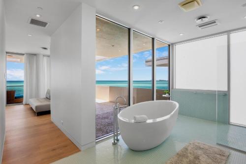 Un baño con bañera y vista al mar. en Siesta Sunset Sanctuary, en Bailey Hall