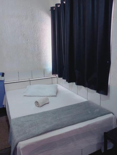 a bed in a room with a black curtain at Hot Iguaçú in Sorocaba