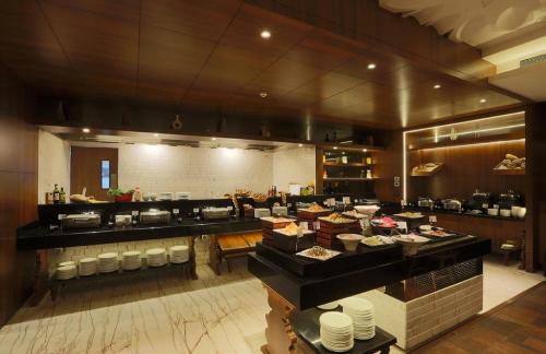 a restaurant with a buffet line with dishes on display at Hotel East End Delhi Aiport in New Delhi