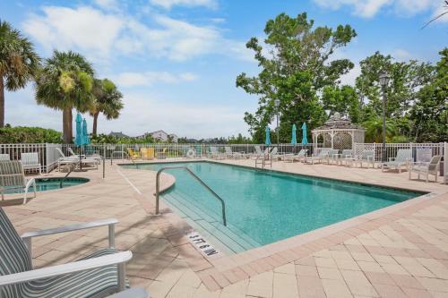 a swimming pool at a resort with chairs and trees at Penthouse Paradise in Siesta Key